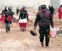  ?? Hadi Mizban / AP Photo ?? Iraqis bring heating fuel to their families in a refugee camp in Khazir, near Mosul.