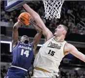  ?? AP ?? Utah State’s Josh Uduje (14) heads to the basket as Purdue’s Zach Edey (15) defends Sunday during the NCAA Tournament in Indianapol­is. Lightning rod Edey led Purdue with 23 points and 14 rebounds in their 106-67 win.