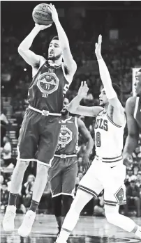  ?? AP ?? CAN’T STOP ME. Golden State Warriors’ Klay Thompson, left, shoots past Chicago Bulls’ Zach LaVine (8) during the first half of an NBA basketball game Friday, Jan. 11, 2019, in Oakland, Calif.