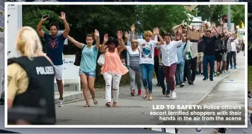  ??  ?? LED TO SAFETY: Police officers escort terrified shoppers with their hands in the air from the scene