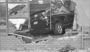  ?? RCMP ?? An SUV rests on debris after being driven through the front window of the Peachland library.