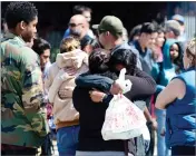  ?? AP PHOTO BY DEAN MUSGROVE ?? Students are reunited with family members outside Highland High School in Palmdale as the Sheriff took the school off lockdown on Friday.