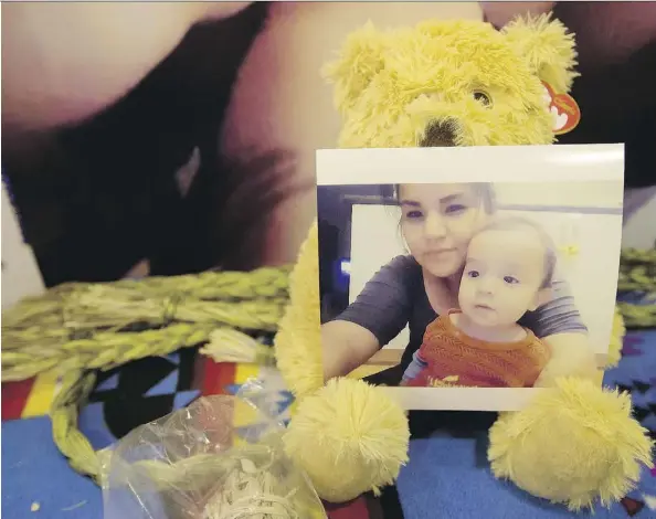  ?? DAVID BLOOM ?? A photo of Dalyce Raine and her son Anthony Joseph Raine sits on a stuffed animal inside the Chief Peter Bull Memorial Centre on Monday.