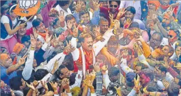  ?? ARVIND YADAV/HT ?? Uttar Pradesh Bharatiya Janata Party president Keshav Prasad Maurya (centre) celebrates the saffron party’s massive victory with party supporters in Lucknow on Saturday.