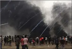  ?? PHOTO/ KHALIL HAMRA ?? Teargas canisters fired by Israeli troops fall over Palestinia­n protesters gathered during a protest at the Gaza Strip’s border with Israel, on Friday. AP