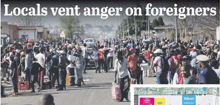  ?? Picture: Nigel Sibanda ?? FREE-FOR-ALL. People looting foreigner-owned shops at White City in Soweto yesterday – watched by a policeman, bottom right – after an owner of a spaza shop was accused of killing a local teen.