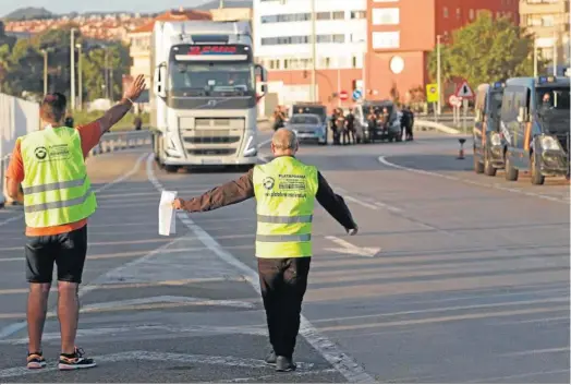  ?? ERASMO FENOY ?? Dos miembros de un piquete informativ­o dan el alto a un camión en el Acceso Sur al Puerto.