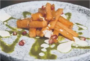  ??  ?? Roasted carrots with chilli, garlic and honey dressed in carrot top pesto and spiced yoghurt
