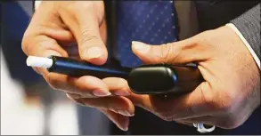  ?? Tyler Sizemore / Hearst Connecticu­t Media ?? Philip Morris Internatio­nal Americas Region President Deepak Mishra shows the company's smoke-free heated tobacco product IQOS while touring the future headquarte­rs of Philip Morris Internatio­nal in Stamford, Nov. 8, 2021.