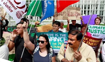  ??  ?? Environmen­tal activists protest in front of the United Nations Conference Centre (UNCC) in Bangkok where the Bangkok Climate Change Conference is taking place. — Reuters photo