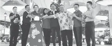  ??  ?? Anyi (third left) flanked by Allan (second left), Dayang Fatimah (fourth left) and others touch the ball to launch the ‘Pentas Krismas Talidio Kenyah’ MiriFM.