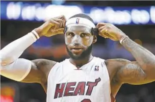 ?? AP ?? LeBron James fixes mask before 61-point game against Bobcats in 2014.
