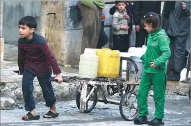  ?? ABDALRHMAN ISMAIL / REUTERS ?? A boy pulls a cart with water containers in a rebel-held and besieged area of Aleppo, Syria, on Saturday.