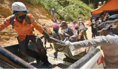  ??  ?? Indonesian rescue workers removing a body of a miner from a collapsed mine in Bolaang Mongondow, North Sulawesi.