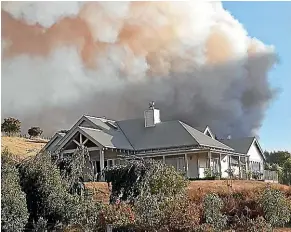  ??  ?? When Guy Mollett photograph­ed his Redwood Valley home on Tuesday as he evacuated, he was certain he’d be returning to its charred remains.