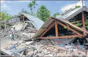  ?? AFP ?? A man looks at houses flattened after a 6.4magnitude earthquake struck Lombok, Indonesia, on Sunday.