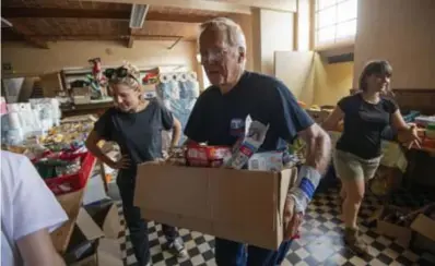  ??  ?? Vrijwillig­ers brengen in Pepinster dozen met hulpgoeder­en naar de zwaarst getroffen gezinnen.