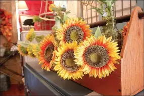  ?? PHOTOS BY LYNN KUTTER ENTERPRISE-LEADER ?? Many simple items can be used to decorate the home for fall. Using silk sunflowers in a basket is one idea.