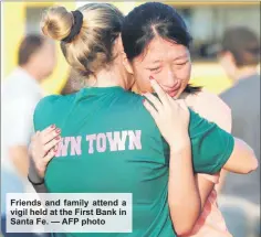  ??  ?? Friends and family attend a vigil held at the First Bank in Santa Fe. — AFP photo