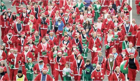  ?? | ?? PEOPLE take part in a charity race in Madrid, Spain, yesterday. More than 7 000 participan­ts dressed as Santa Claus and ran through the Spanish capital to raise money for cancer care. Organisers say the Santa-themed race is the largest of its kind in the world. REUTERS