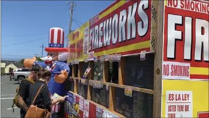  ?? PHOTOS BY SHOMIK MUKHERJEE — THE TIMES-STANDARD ?? Customers look into the products sold at a TNT Fireworks stand nearby Wildberrie­s Marketplac­e in Arcata.