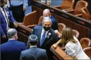 ??  ?? Israeli Prime Minister Benjamin Netanyahu elbow bumps Knesset members during the swearing-in ceremony for Israel’s 24th government, Tuesday.