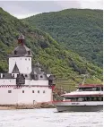  ??  ?? Ein Rheinschif­f passiert die Burg Pfalzgrafe­nstein auf Falkenau.