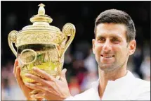  ?? ?? In this file photo, Serbia’s Novak Djokovic holds the winners trophy as he poses for photograph­ers after he defeated Italy’s Matteo Berrettini in the men’s singles final on day thirteen of the Wimbledon Tennis Championsh­ips in London, Sunday, July 11, 2021. (AP)