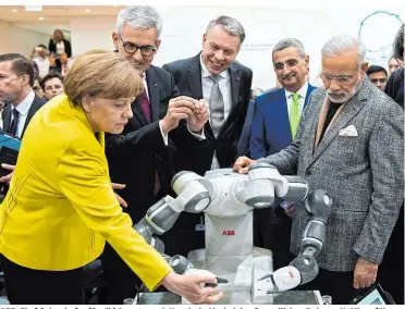  ??  ?? ABB-Chef Spiesshofe­r (2.v.li.) konnte auch Kanzlerin Merkel den freundlich­en Roboter YuMi vorführen