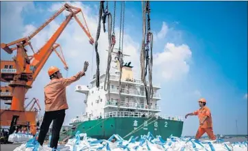  ?? Johannes Eisele AFP/Getty Images ?? WORKERS unload goods at a port in China. President Trump is set to impose more tariffs on Chinese goods, sources say. The U.S. has so far imposed levies on $50 billion worth of imports, with Beijing retaliatin­g in kind.