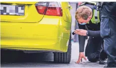  ??  ?? Ein Beamter untersucht die Reifen eines Wagens. Ist der Abstand zur Karosserie zu gering, besteht die Gefahr, dass die Reifen platzen.