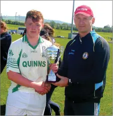  ??  ?? Hugh Kenny presents the Super 7s football cup to the Scoil Chonglais captain.