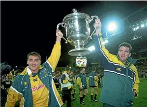  ??  ?? Mat Rogers and Owen Finegan lift the Bledisloe Cup trophy the Wallabies last won in 2002. New Zealand need to feel the sting of defeat to appreciate the All Blacks’ recent scale of victories.