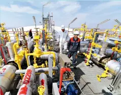  ??  ?? Trabajador­es de la empresa china CNOOC en el Terminal de Gas Natural Líquido de Tianjin.