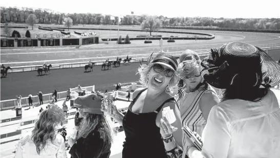  ?? E. JASON WAMBSGANS/CHICAGO TRIBUNE ?? Jennifer Daly, center, of Naperville, laughs with friends at opening day at Arlington Internatio­nal Racecourse on April 30.