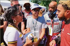  ?? Dan Gelstoin / Associated Press ?? NASCAR driver Kyle Larson, center, talks with members of the Urban Youth Racing School before the start of a race on the grounds of the Please Touch Museum in Philadelph­ia on Friday.