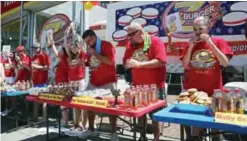  ??  ?? WASHINGTON: Molly Schuyler (right), who is #1 ranked competitiv­e eater in the world, eats a hamburger’s during Z Burger’s eighth annual Independen­ce Burger Eating Championsh­ip in Washington, DC. Molly beat her competitio­n by eating 21 hamburgers. —AFP