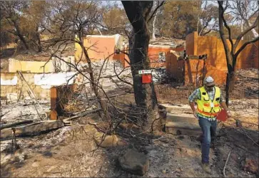  ?? Genaro Molina Los Angeles Times ?? A NAPA COUNTY official red tags a home after the Atlas fire in 2017. Areas of wine country that were devastated by wildfire now have some of the lowest poverty rates in the United States, new census data show.