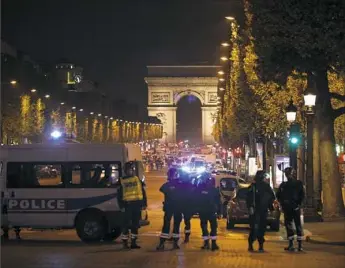  ??  ?? Security forces seal off the Champs-Elysees in Paris on Thursday after shootings in which a police officer was killed along with an attacker. Two other officers were wounded.