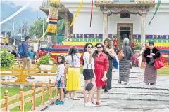  ??  ?? Regional tourists take selfies at the National Memorial Chorten that devout Bhutanese visit every day to offer prayers in the Bhutanese capital Thimphu.