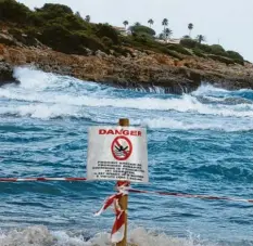  ?? Foto: Clara Margais, dpa ?? Ein Schild verbietet das Schwimmen am Strand von Cala Mendia in Manacor auf Mal‰ lorca. Zwei junge Urlauberin­nen sind hier ertrunken.