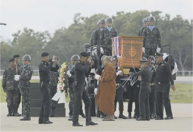  ??  ?? The body of Saman Gunan, who died during an overnight mission, is carried during a repatriati­on and religious rites ceremony at Chiang Rai Airport