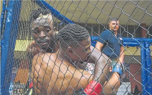  ?? Picture: GAMBIT PHOTOGRAPH­Y ?? HARD-FOUGHT BATTLE: PESFA fighter Cedric Mbala gains the upper hand over Awuzza Dix Anz in their welterweig­ht clash at the God of War MMA tournament at the weekend