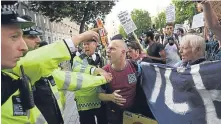  ??  ?? Police step in as protesters call for justice for Grenfell victims.