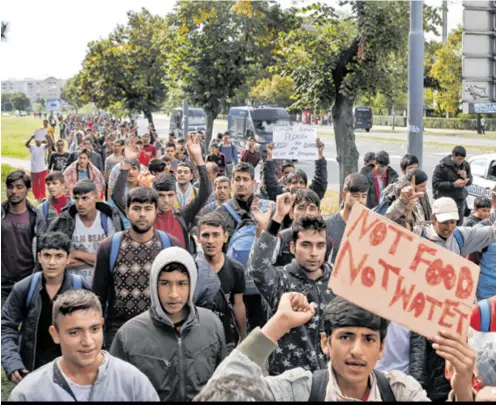  ??  ?? PROSVJED Više stotina migranata krenulo je jučer pješice iz Beograda prema granici s Mađarskom. U koloni koja je blokirala promet bili su uglavnom muškarci u dobi do 30 godina. Tražili su otvaranje granica