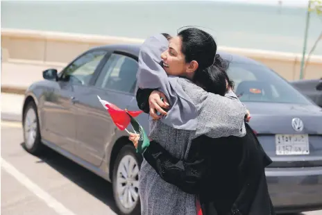  ?? AFP; Reuters; Getty; EPA ?? Delighted to drive: clockwise from left, Fadya Fahad, one of the first female drivers for Careem in Jeddah; Bahraini Nouf Al Maloud, right, hugs Saudi Zahoor Assiri to congratula­te her; Halah Reda on the road for a coffee run; having the tank filled; Majdoleen Alateeq drives next to a poster of King Salman; advertisin­g targeted at women; Nada Edlibi proudly shows her licence