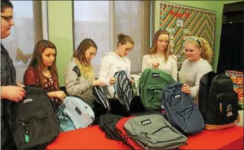  ?? LAUREN HALLIGAN — LHALLIGAN@DIGITALFIR­STMEDIA.COM ?? Heatly School student council members prepare to stuff backpacks with food for the BackPack Program, which gives students in need food to take home over weekends and school breaks.