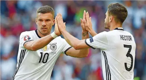  ?? FOTO: IMAGO ?? Lukas Podolski (links) klatscht mit dem Auersmache­r Jonas Hector ab. Morgen trägt Poldi zum letzten Mal das Nationaltr­ikot.