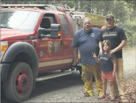 ?? CARIN DORGHALLI — ENTERPRISE-RECORD ?? Reed Rankin, volunteer fire chief of Berry Creek, poses with James “Woody” Faircloth and Luna Faircloth, 8, on Sunday, in Oroville. Rankin lost his home, business and fire station in the North Complex West Zone fires.