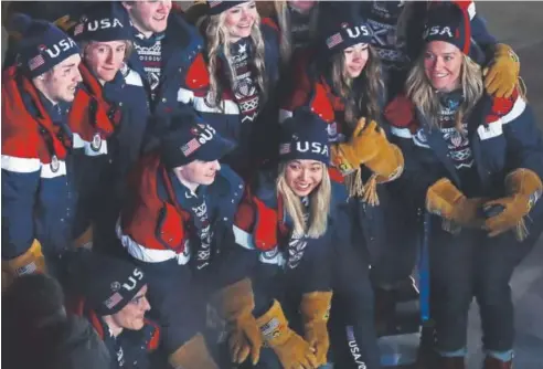  ?? Al Bello, Getty Images ?? Teenage snowboarde­r Chloe Kim, center, is all smiles Friday as the U.S. Olympic team participat­es in the opening ceremony at the PyeongChan­g Games in South Korea. Kim, a contender for Olympic gold, has become one of the best switch riders in her sport.